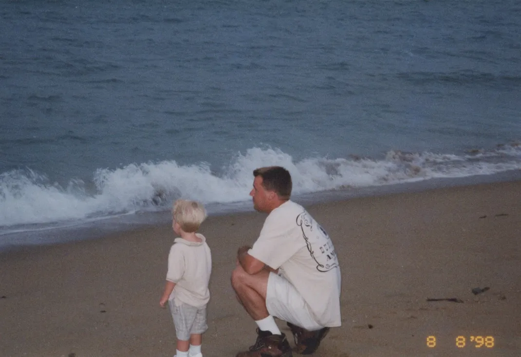 Chuck Garrett and his son Colin standing together at the shoreline, watching the waves, summer 1998.